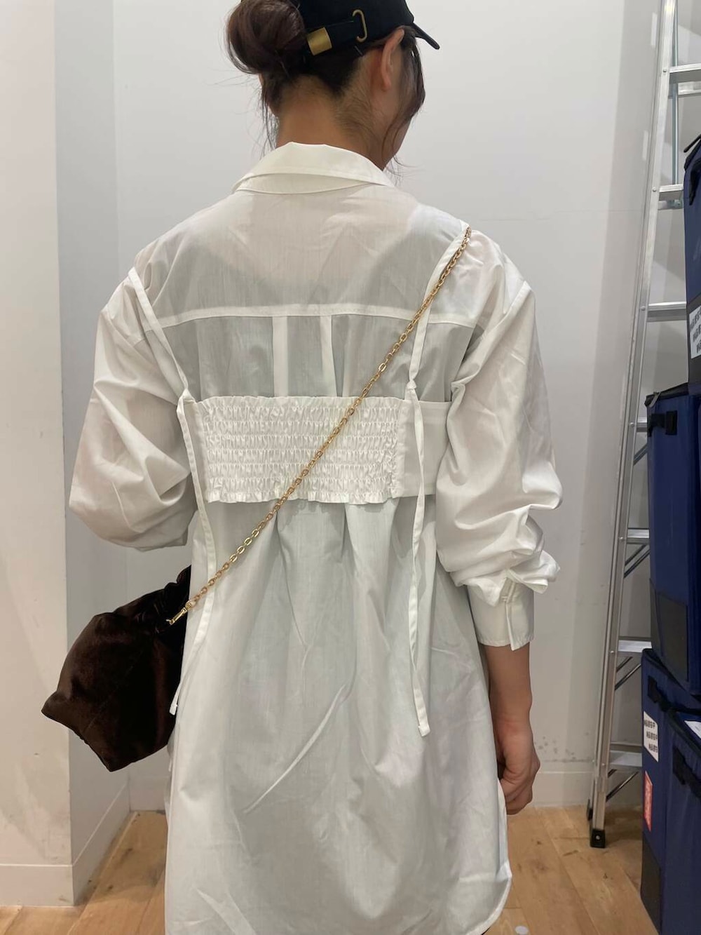 ブラウン系のハンドバッグ、ブラウン系のブーツ、ホワイト系のシャツ/ブラウスを着用したレディースの秋コーディネートの5枚目の写真