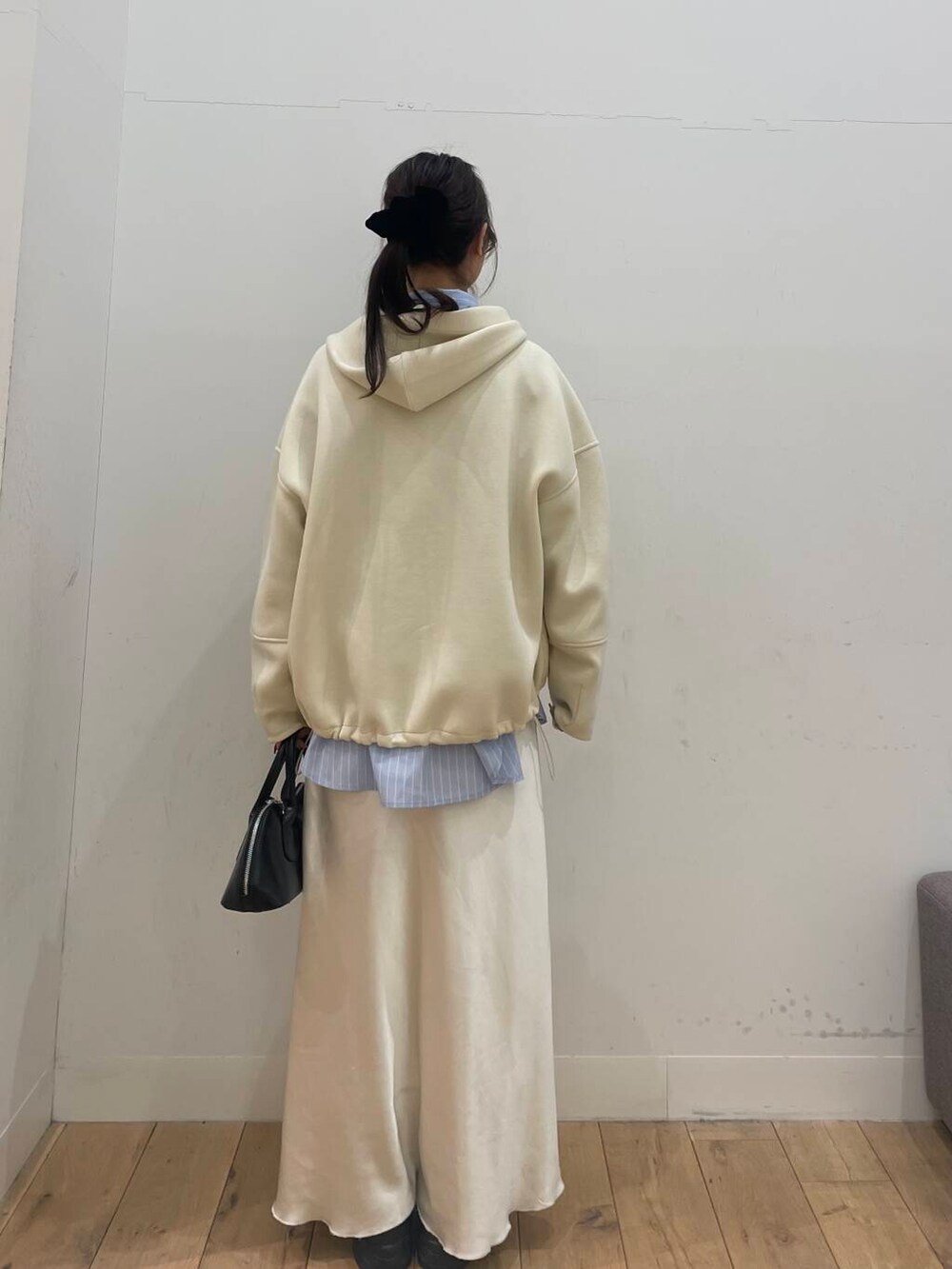 ブラック系のボストンバッグ、ブルー系のシャツ/ブラウス、ホワイト系のスカートを着用したレディースの冬コーディネートの3枚目の写真