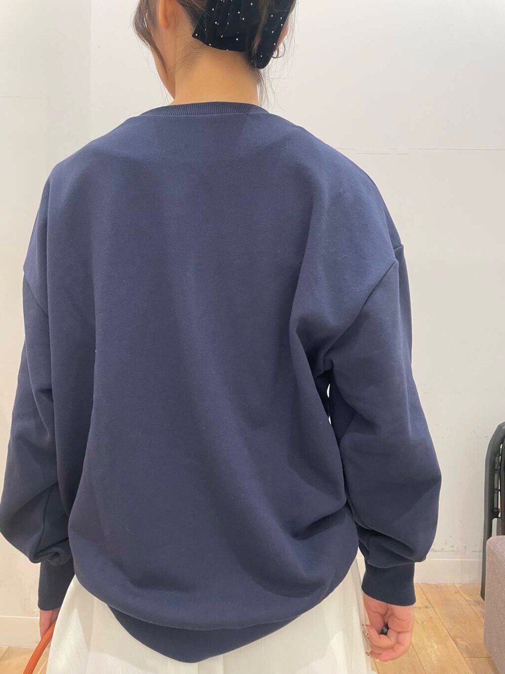 オレンジ系のハンドバッグ、ホワイト系のスカート、ブラック系のパンプスを着用したレディースの冬コーディネートの5枚目の写真