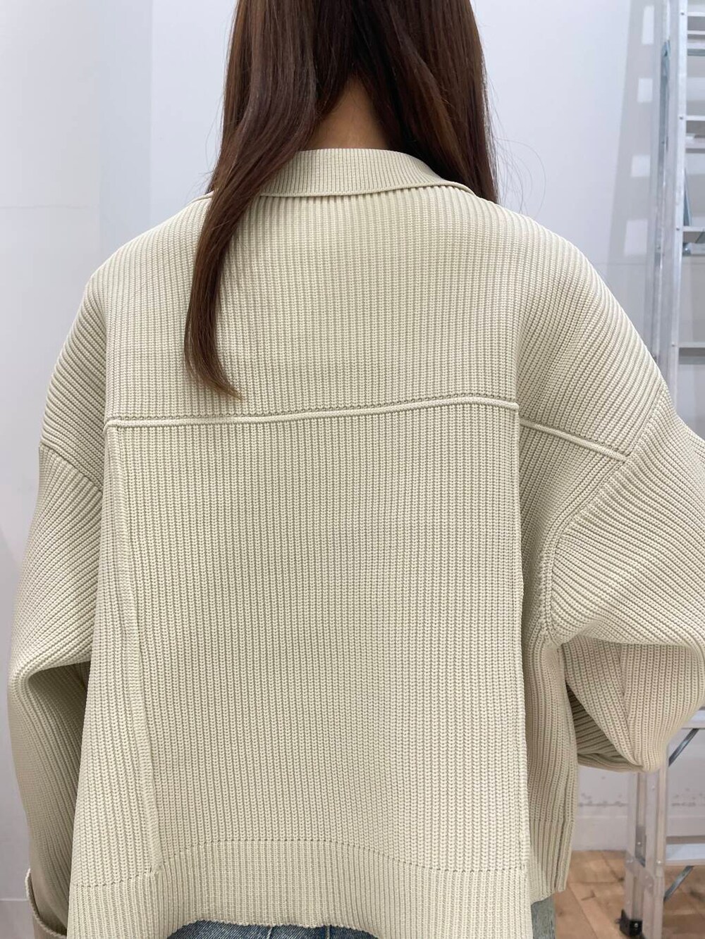 レッド系のボストンバッグ、ブルー系のデニムパンツ、ホワイト系のその他アウターを着用したレディースの冬コーディネートの5枚目の写真