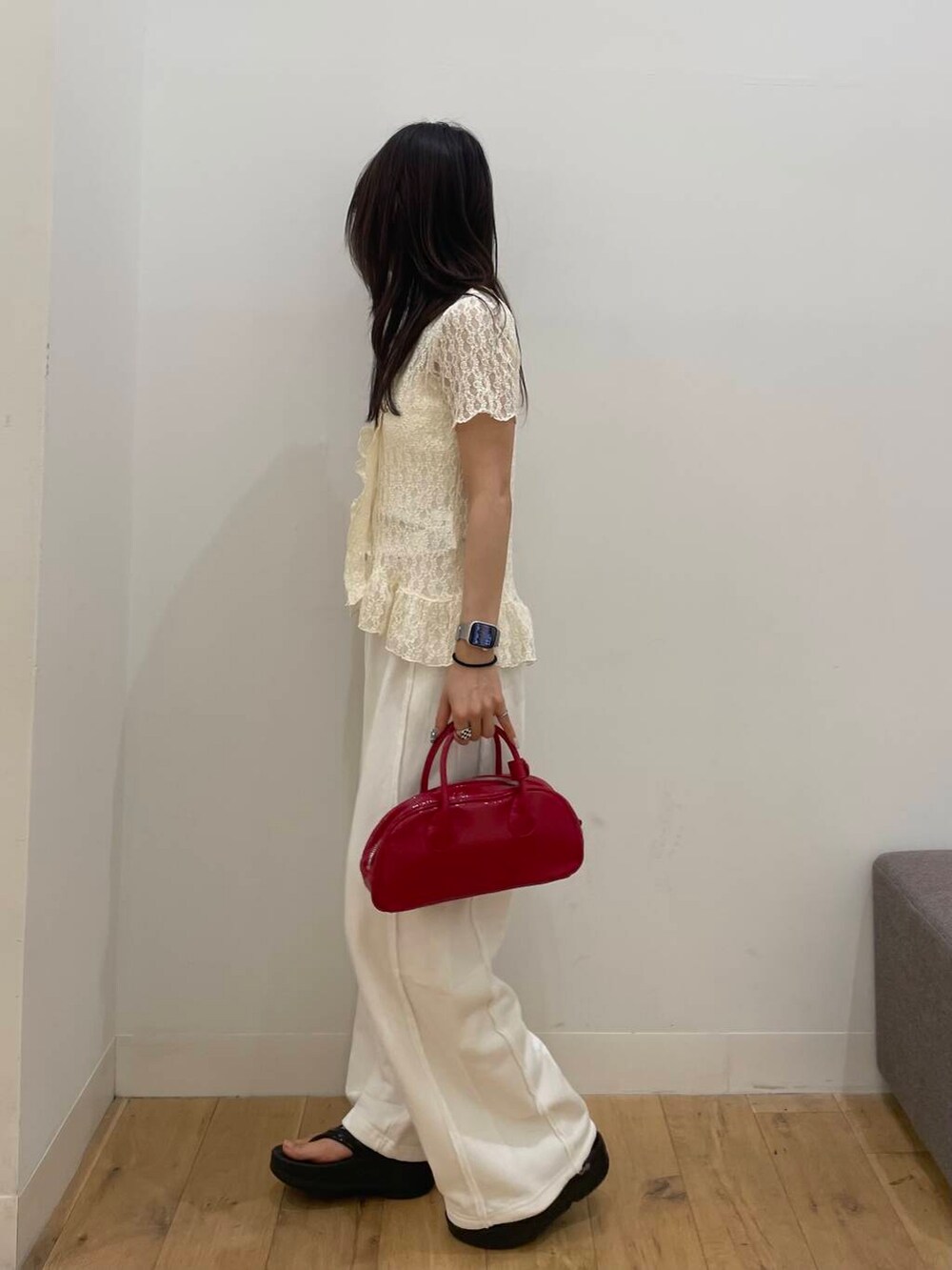 レッド系のボストンバッグ、ホワイト系のシャツ/ブラウスを着用したレディースの夏コーディネートの2枚目の写真
