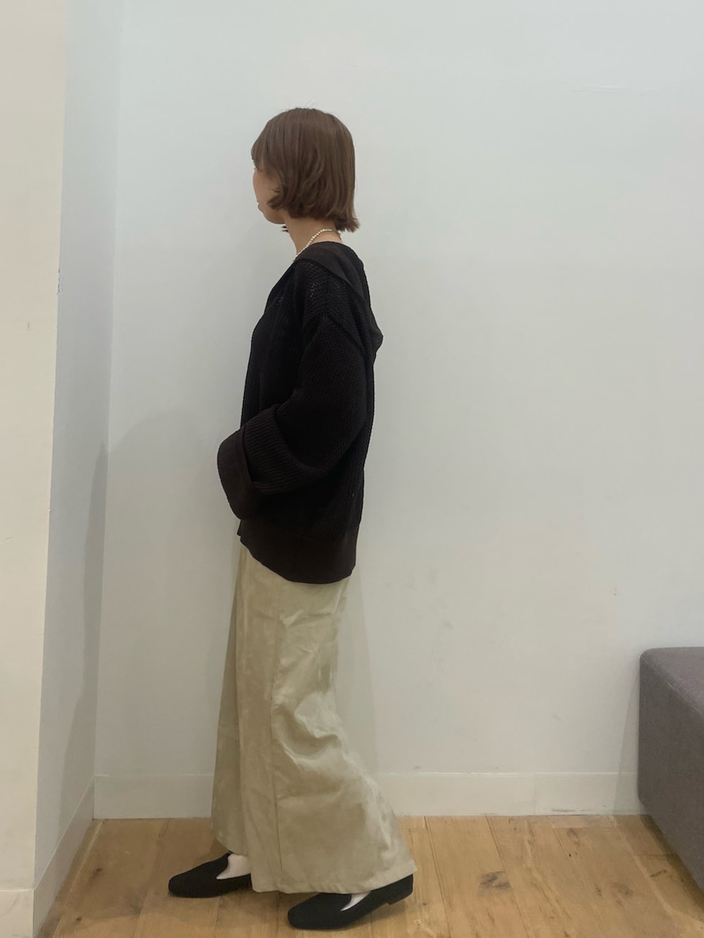 ブラウン系のニット/セーター、ベージュ系のスカートを着用したレディースの秋コーディネートの2枚目の写真