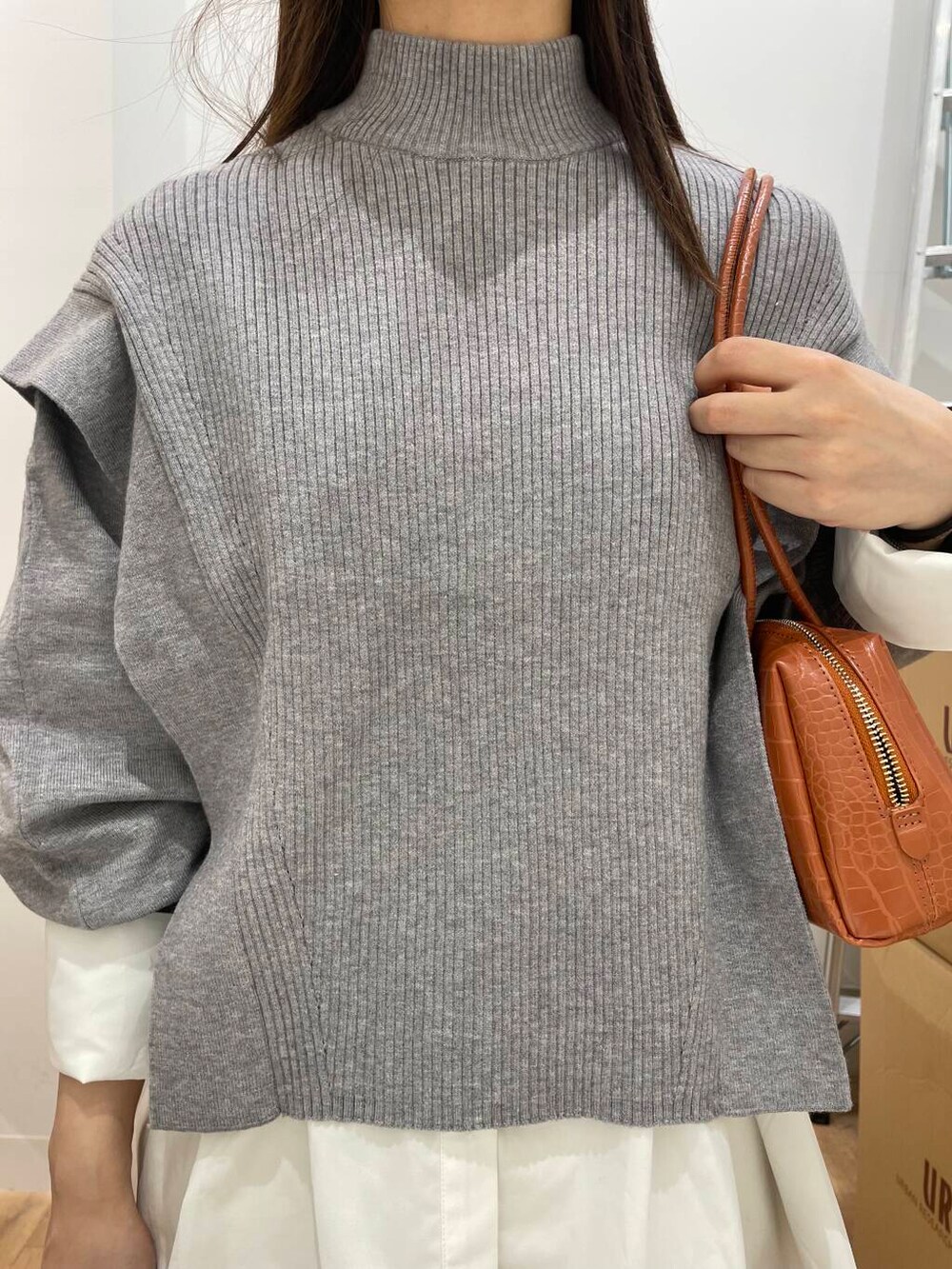 ホワイト系のシャツ/ブラウス、ブラック系のブーツ、オレンジ系のハンドバッグを着用したレディースの秋コーディネートの5枚目の写真