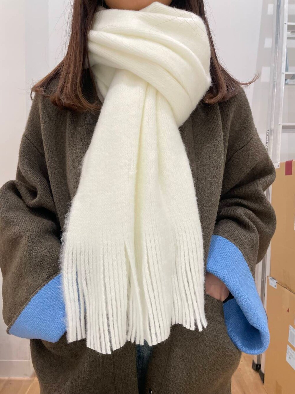 ブルー系のスカート、ブラウン系のその他アウター、ホワイト系のマフラーを着用したレディースの秋コーディネートの4枚目の写真