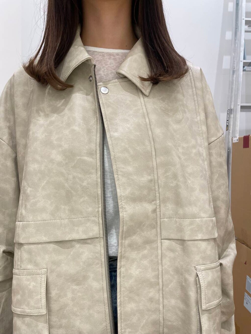 イエロー系のハンドバッグ、ブルー系のスカート、ホワイト系のその他アウターを着用したレディースの秋コーディネートの4枚目の写真