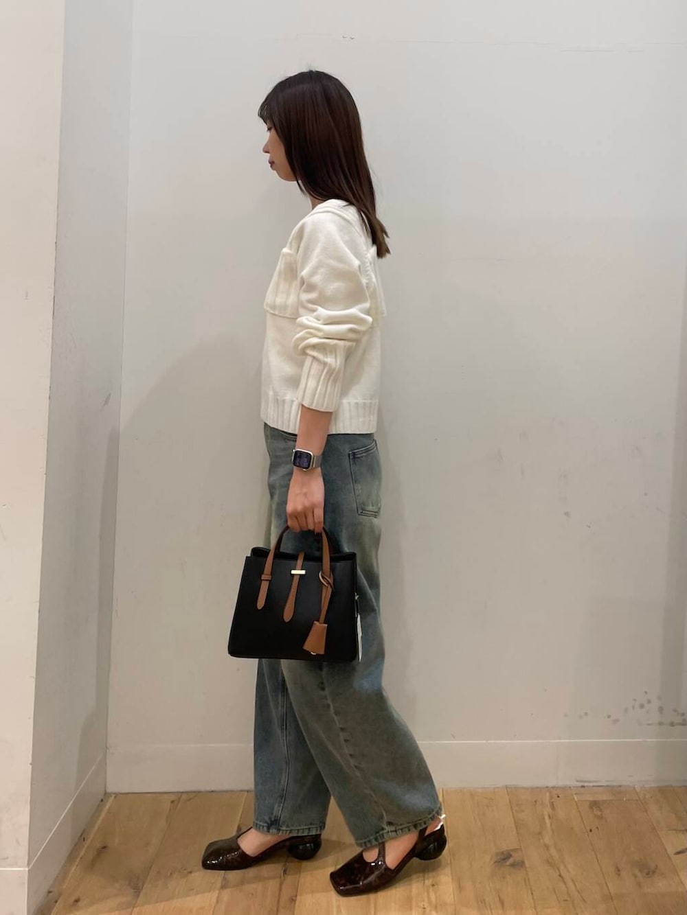 ブラウン系のその他シューズ、ブルー系のデニムパンツ、ホワイト系のニット/セーターを着用したレディースの秋コーディネートの2枚目の写真