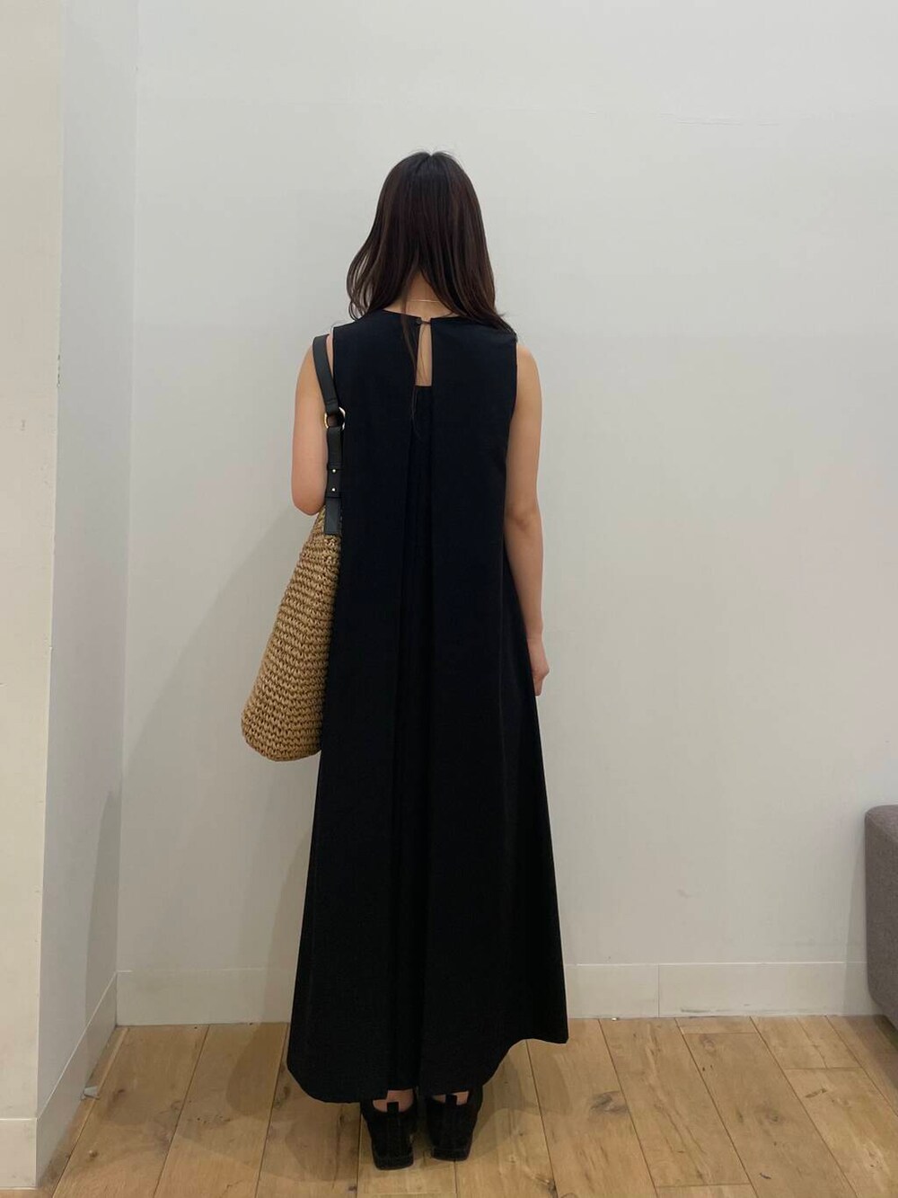 イエロー系のトートバッグ、ブラック系のワンピースを着用したレディースの春コーディネートの3枚目の写真