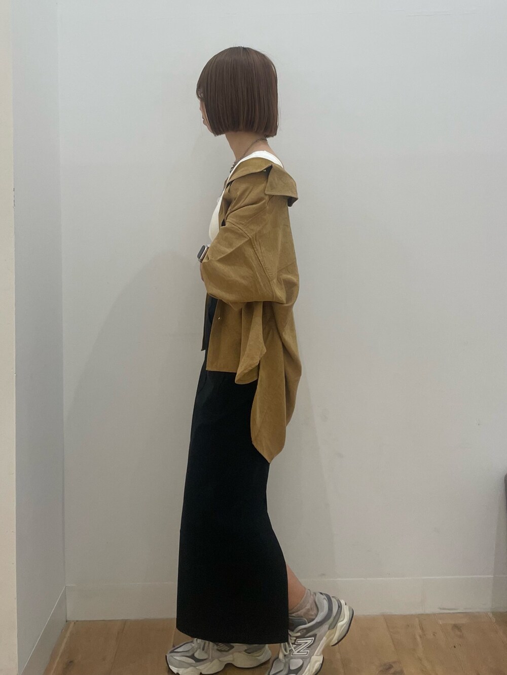 ブラック系のスカート、イエロー系のシャツ/ブラウスを着用したレディースの秋コーディネートの2枚目の写真