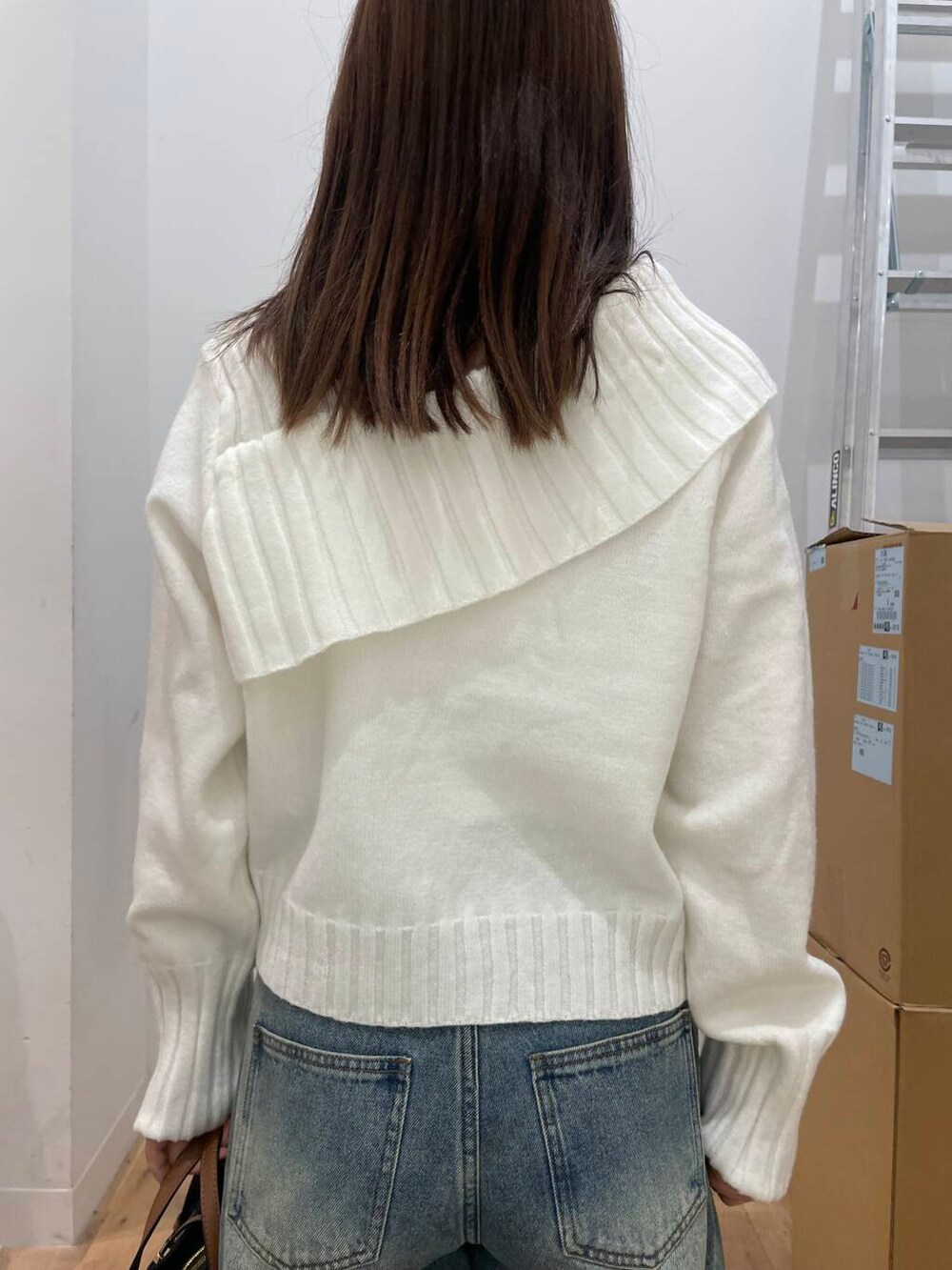 ブラウン系のその他シューズ、ブルー系のデニムパンツ、ホワイト系のニット/セーターを着用したレディースの秋コーディネートの4枚目の写真