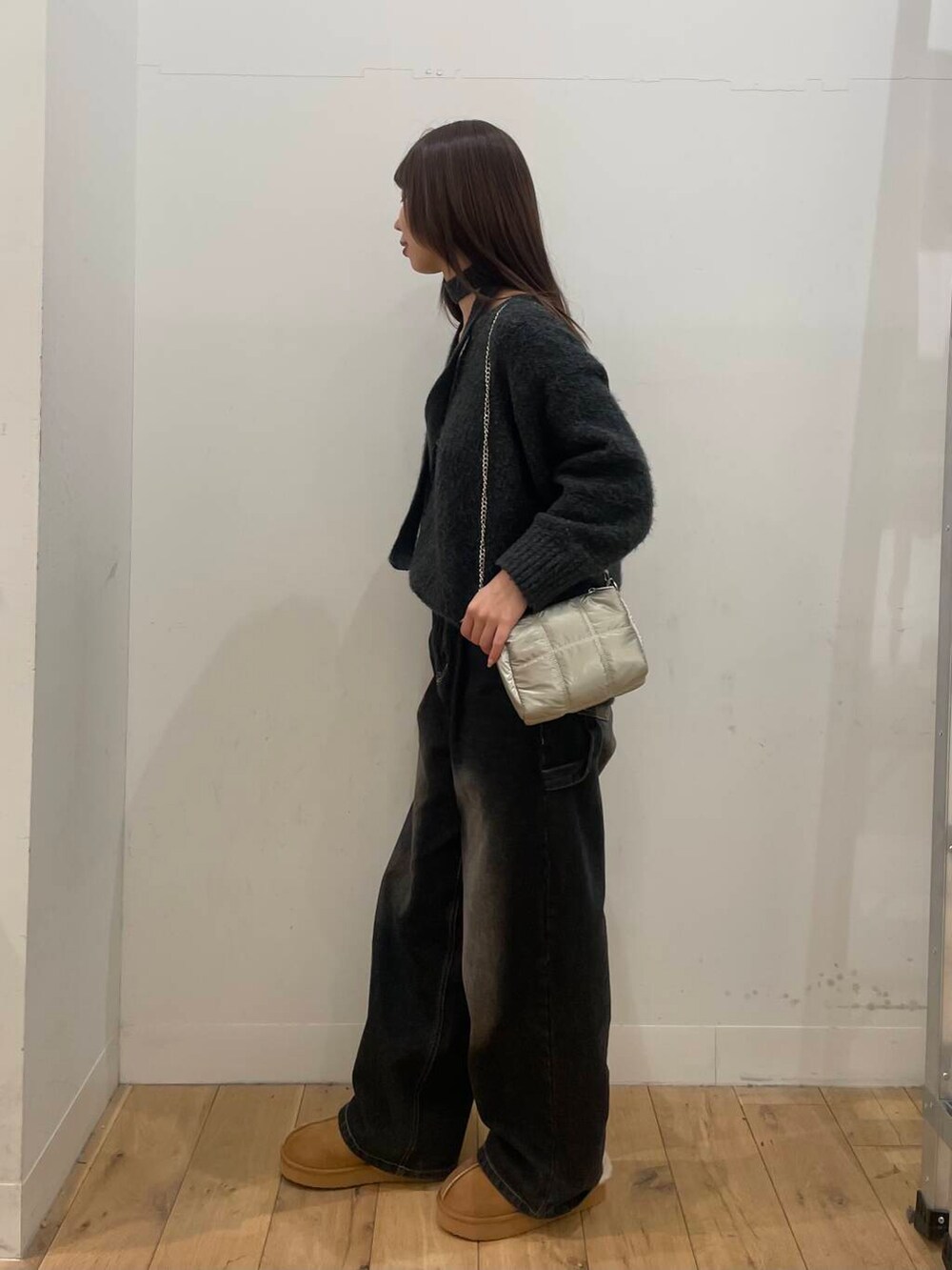 グレー系のニット/セーター、シルバー系のショルダーバッグを着用したレディースの冬コーディネートの2枚目の写真