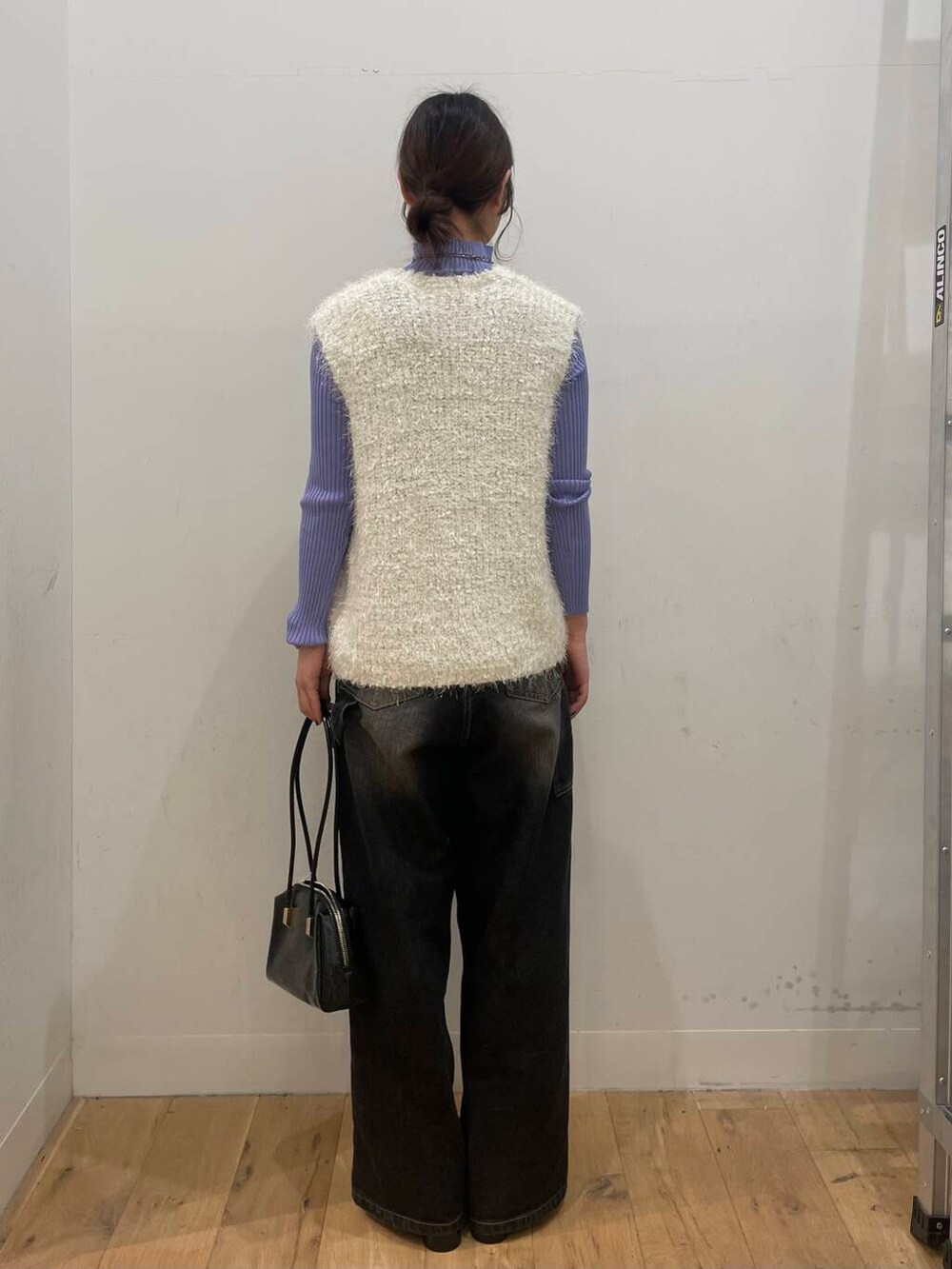 パープル系のニット/セーター、ブラック系のサンダル、ホワイト系のベストを着用したレディースの秋コーディネートの3枚目の写真