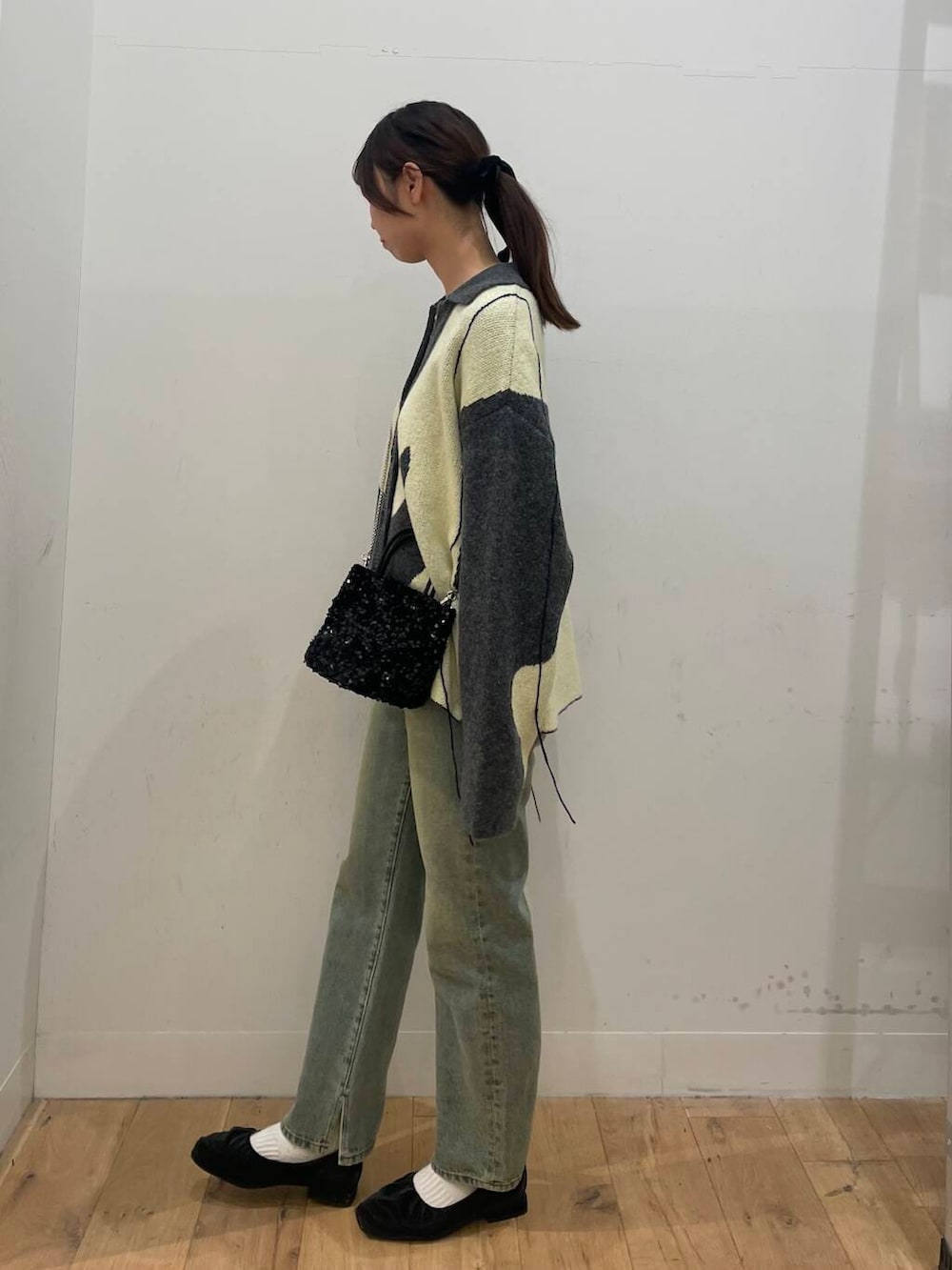 ブラック系のショルダーバッグ、ブルー系のその他パンツ、ホワイト系のTシャツ/カットソーを着用したレディースの秋コーディネートの2枚目の写真