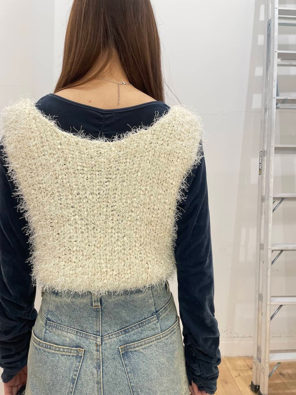 シルバー系のショルダーバッグ、ブルー系のTシャツ/カットソー、ブルー系のデニムパンツを着用したレディースの冬コーディネートの5枚目の写真