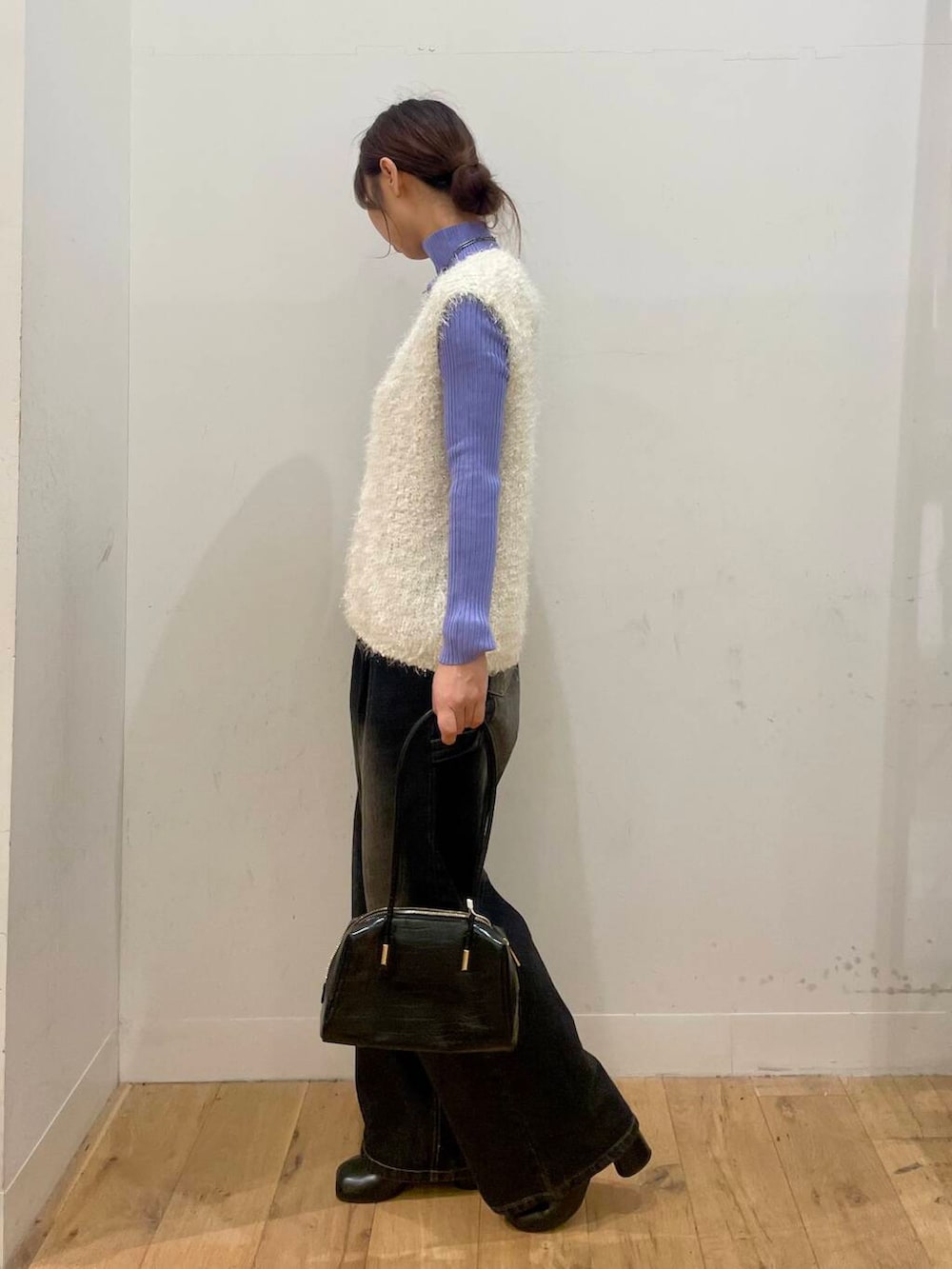 パープル系のニット/セーター、ブラック系のサンダル、ホワイト系のベストを着用したレディースの秋コーディネートの2枚目の写真