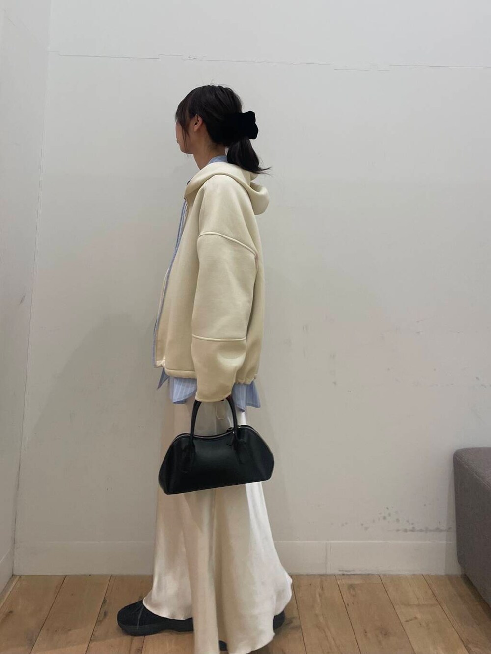 ブラック系のボストンバッグ、ブルー系のシャツ/ブラウス、ホワイト系のスカートを着用したレディースの冬コーディネートの2枚目の写真