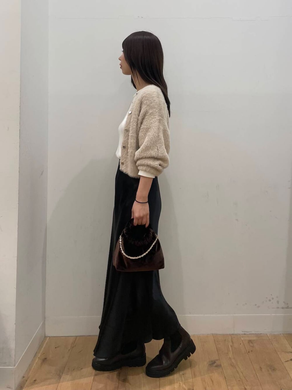 ベージュ系のニット/セーター、ブラウン系のハンドバッグ、ブラウン系のブーツを着用したレディースの秋コーディネートの2枚目の写真