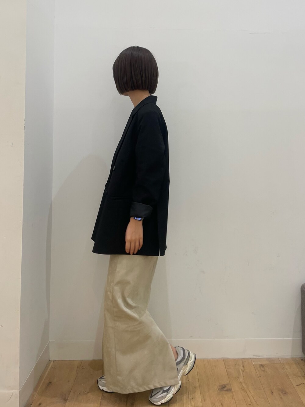 ブラック系のその他アウター、ベージュ系のスカートを着用したレディースの秋コーディネートの2枚目の写真