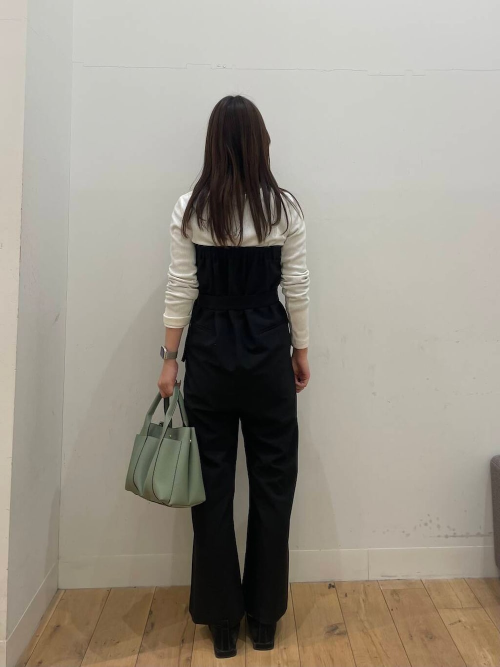 ブラック系のサロペット/オーバーオール、グリーン系のトートバッグを着用したレディースの冬コーディネートの3枚目の写真