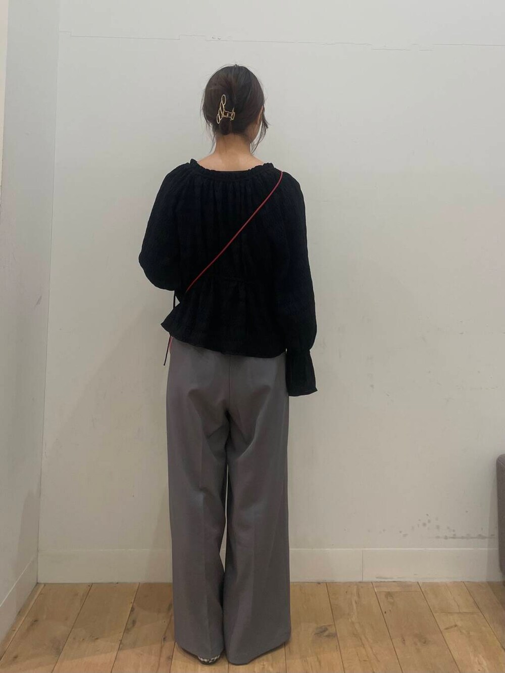 レッド系のショルダーバッグ、ブラック系のシャツ/ブラウス、グレー系のその他パンツを着用したレディースの春コーディネートの3枚目の写真