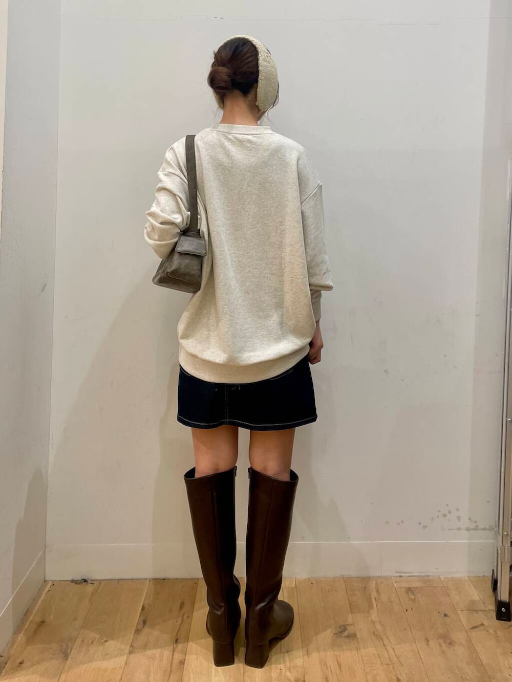 ブラウン系のブーツ、グレー系のハンドバッグ、ブルー系のスカートを着用したレディースの秋コーディネートの3枚目の写真