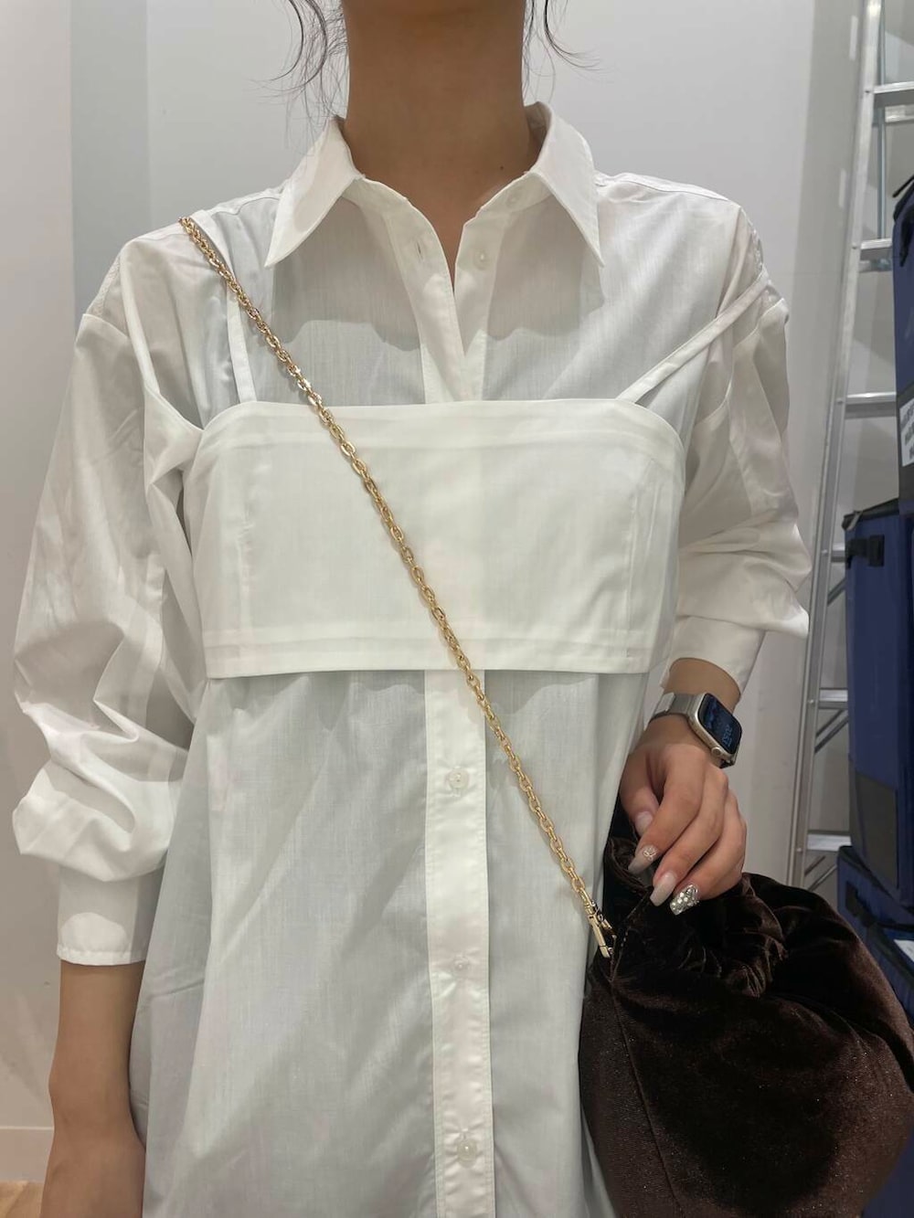 ブラウン系のハンドバッグ、ブラウン系のブーツ、ホワイト系のシャツ/ブラウスを着用したレディースの秋コーディネートの4枚目の写真