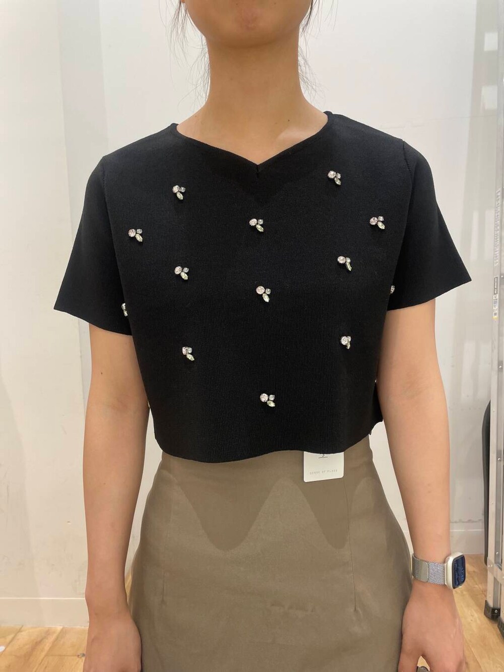 ホワイト系のハンドバッグ、ブラック系のドレスシューズ、ブラック系のニット/セーターを着用したレディースの夏コーディネートの4枚目の写真