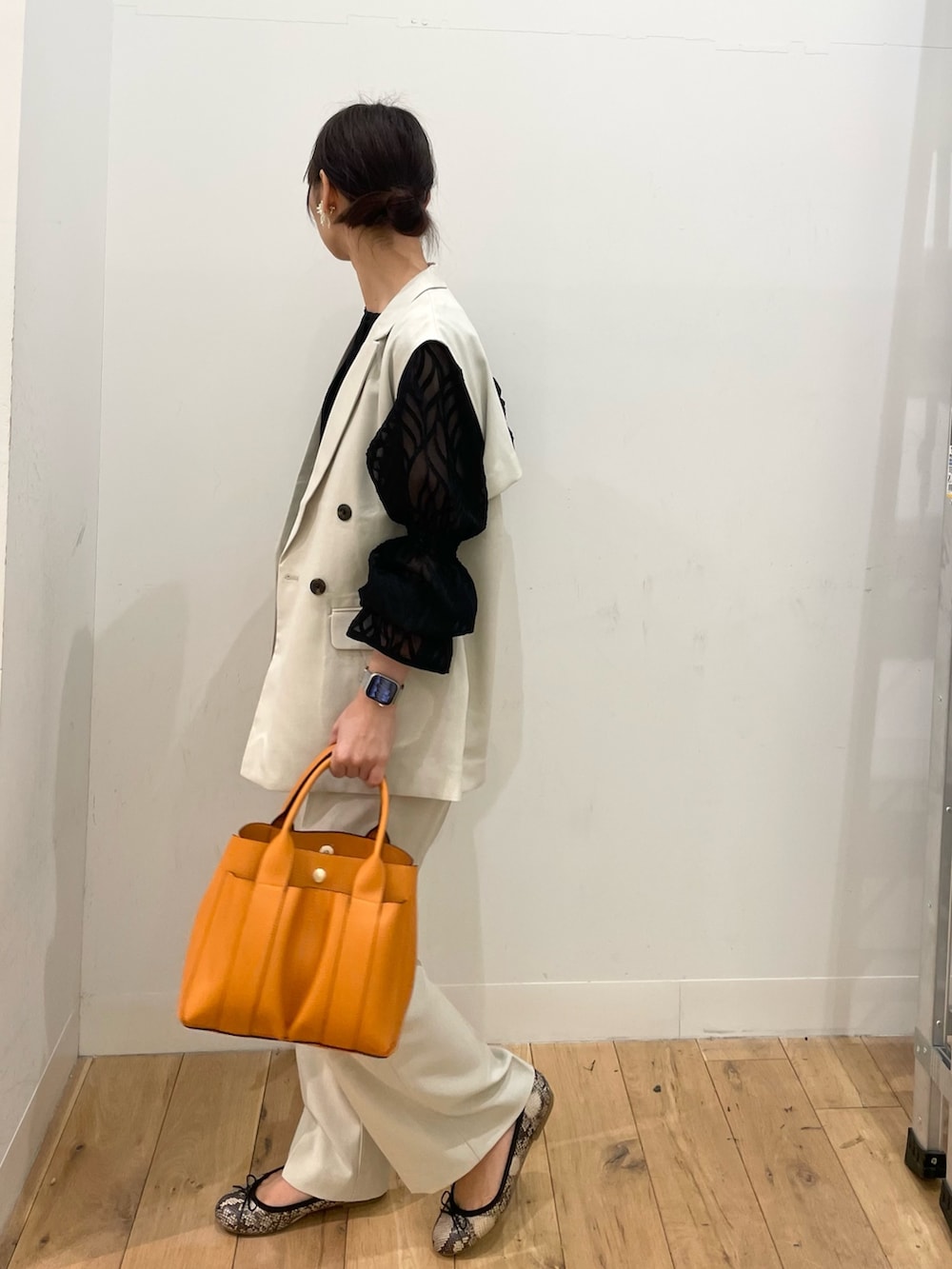 ベージュ系のその他アウター、ベージュ系のその他パンツ、オレンジ系のトートバッグを着用したレディースの春コーディネートの2枚目の写真