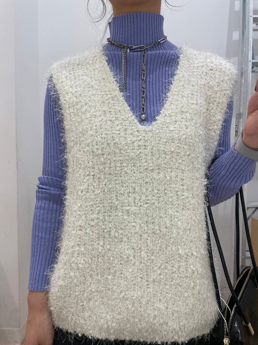 パープル系のニット/セーター、ブラック系のサンダル、ホワイト系のベストを着用したレディースの秋コーディネートの4枚目の写真