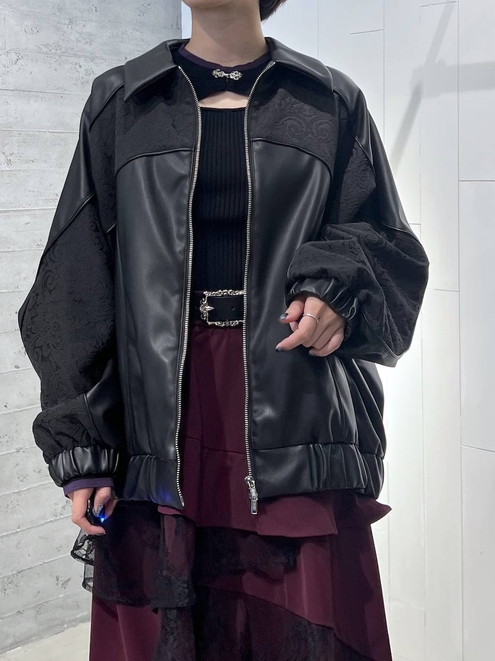 ブラック系のニット/セーター、ブラック系のブルゾン、ブラック系のブーツを着用したレディースの秋コーディネートの2枚目の写真