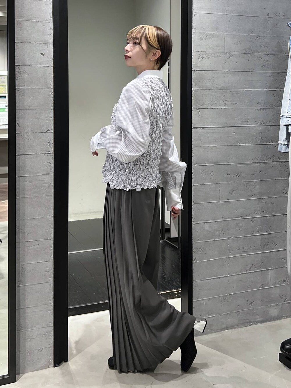 ブラック系のブーツ、ホワイト系のシャツ/ブラウス、グレー系のスラックスを着用したレディースの冬コーディネートの4枚目の写真