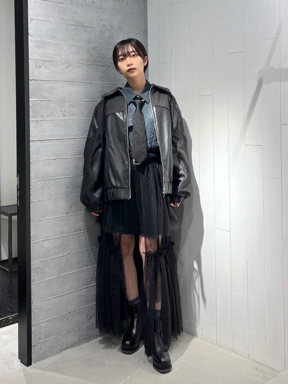 ブラック系のネクタイ、ブラック系のブルゾン、ブラック系のその他パンツを着用したレディースの秋コーディネートの5枚目の写真