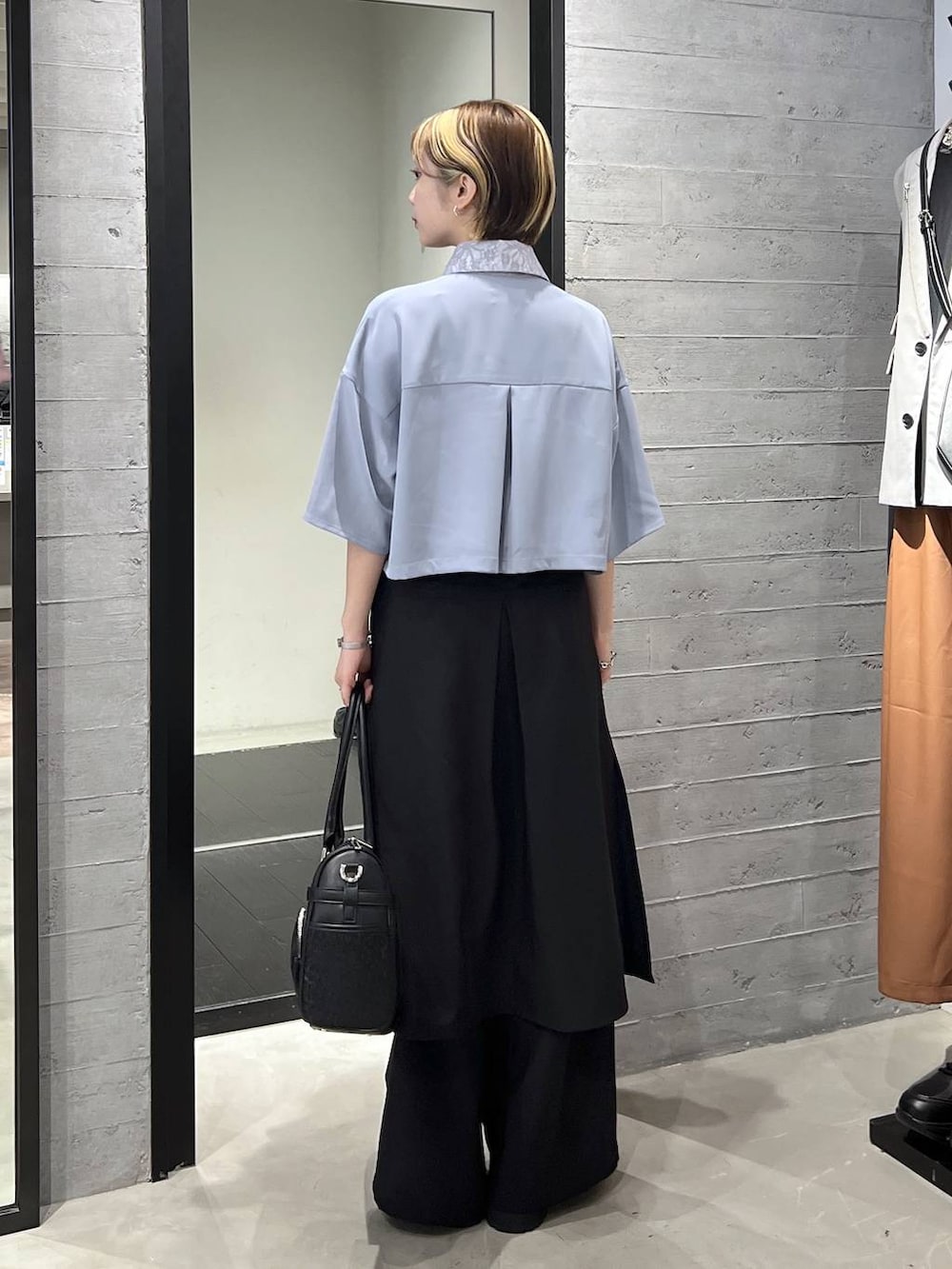 ブラック系のサンダル、ブラック系のボストンバッグ、ブルー系のシャツ/ブラウスを着用したレディースの春コーディネートの5枚目の写真