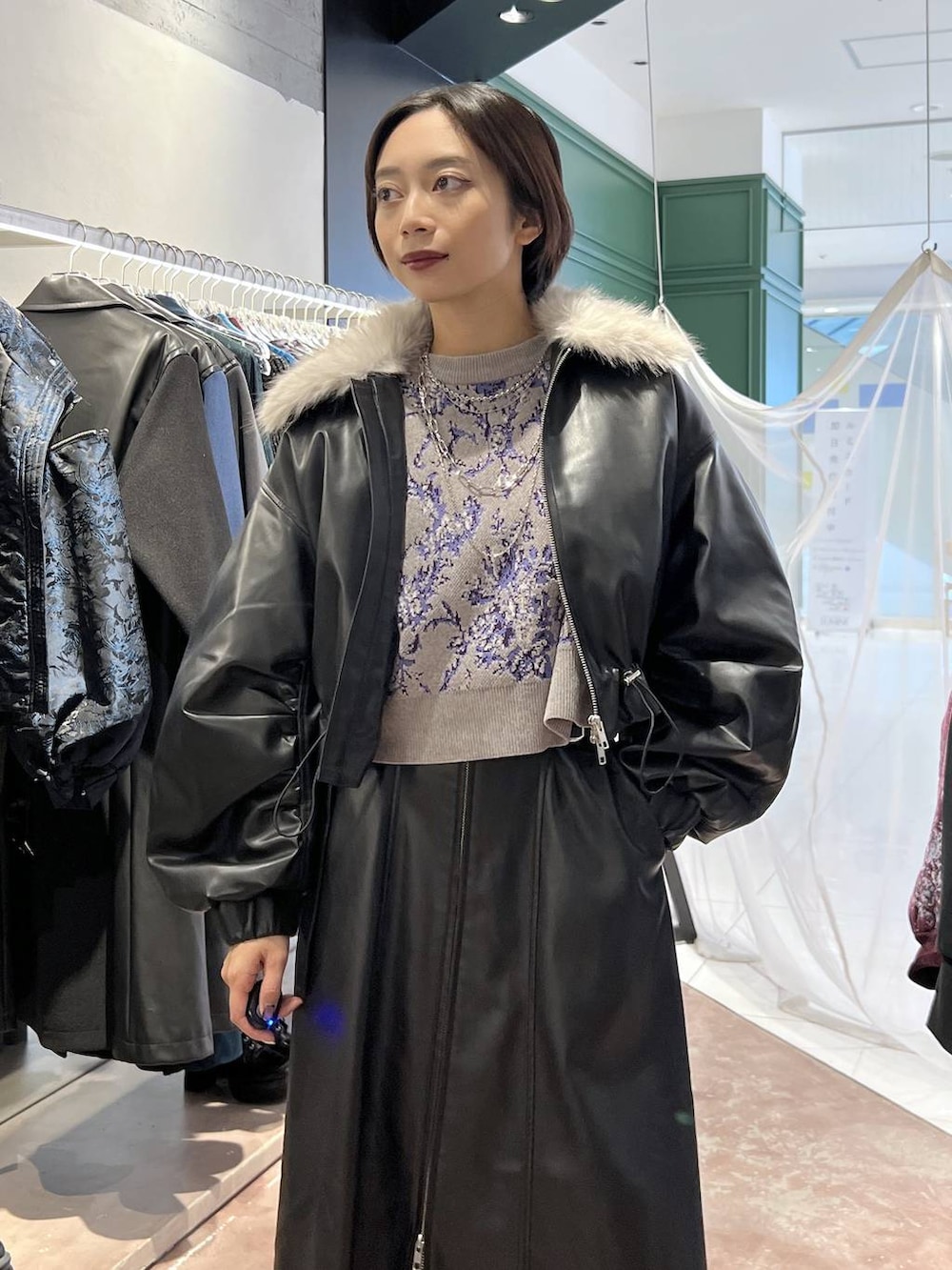 グレー系のニット/セーター、ブラック系のブーツ、ブラック系のブルゾンを着用したレディースの秋コーディネートの2枚目の写真