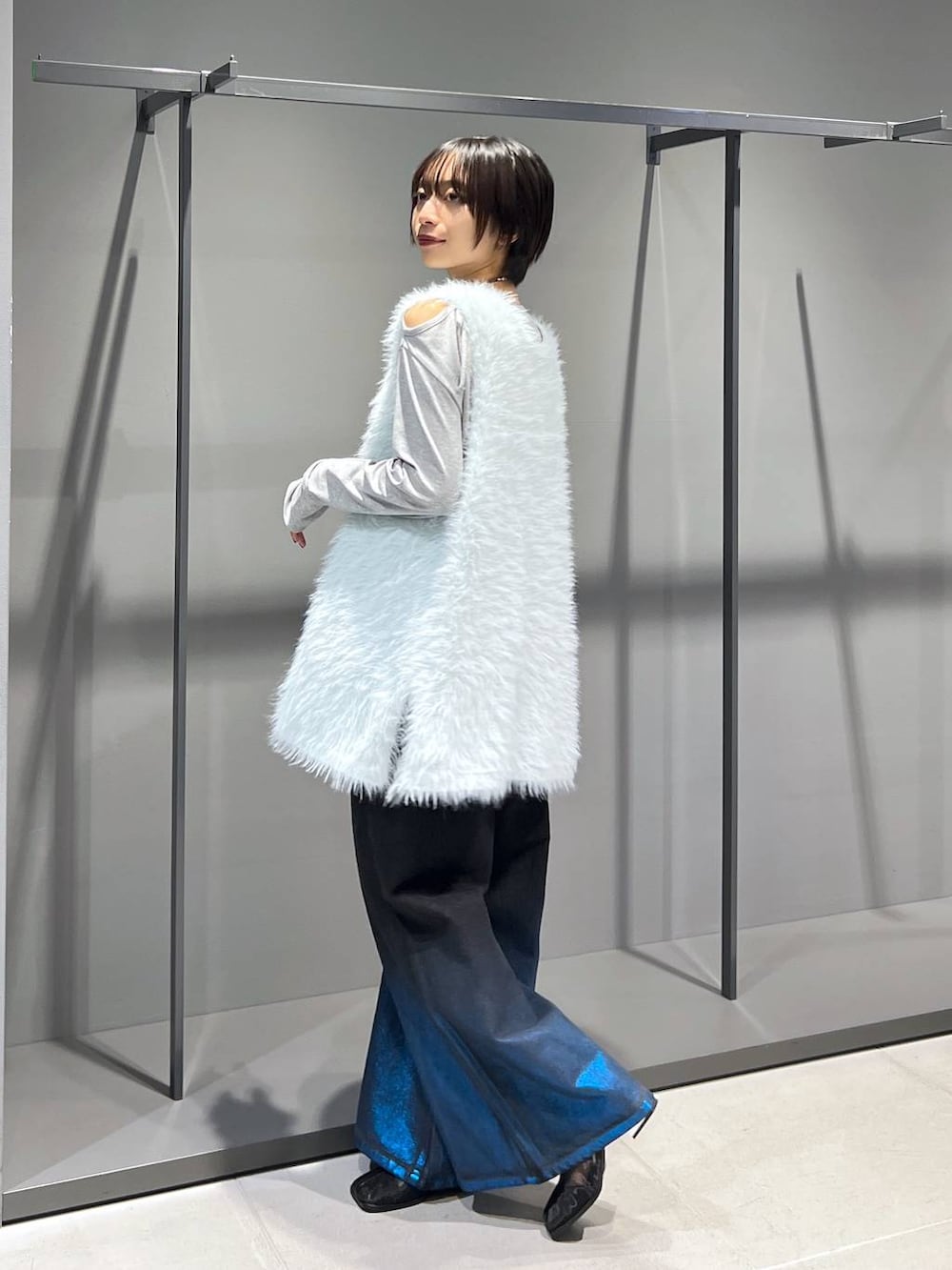 グリーン系のカーディガン/ボレロ、グレー系のTシャツ/カットソー、ブラック系のブーツを着用したレディースの秋コーディネートの4枚目の写真