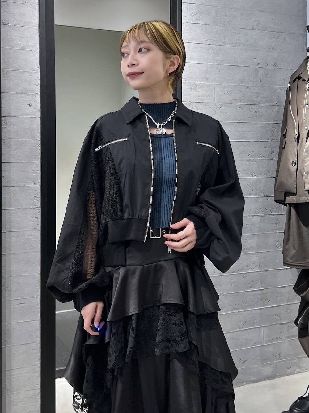 ブラック系のブーツ、ブラック系のスカート、ブラック系のブルゾンを着用したレディースの春コーディネートの2枚目の写真