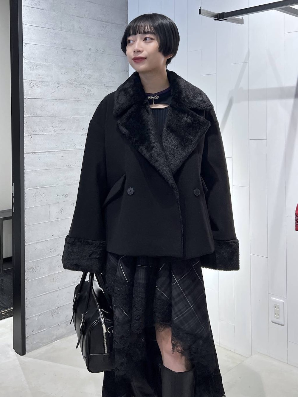 ブラック系のピーコート、ブラック系のニット/セーター、ブラック系のボストンバッグを着用したレディースの秋コーディネートの5枚目の写真