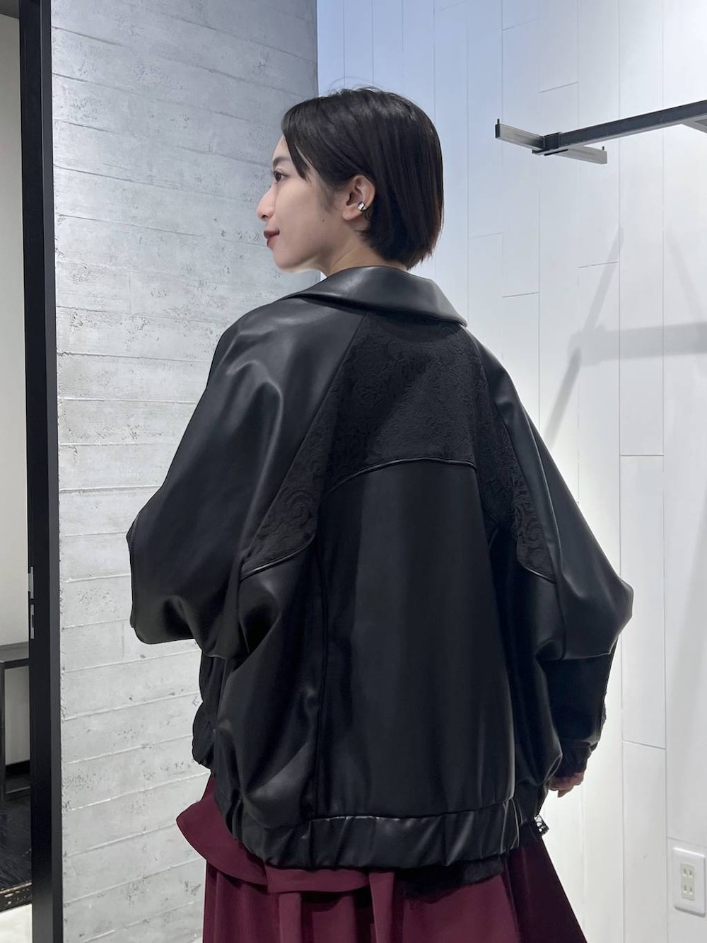 ブラック系のニット/セーター、ブラック系のブルゾン、ブラック系のブーツを着用したレディースの秋コーディネートの3枚目の写真