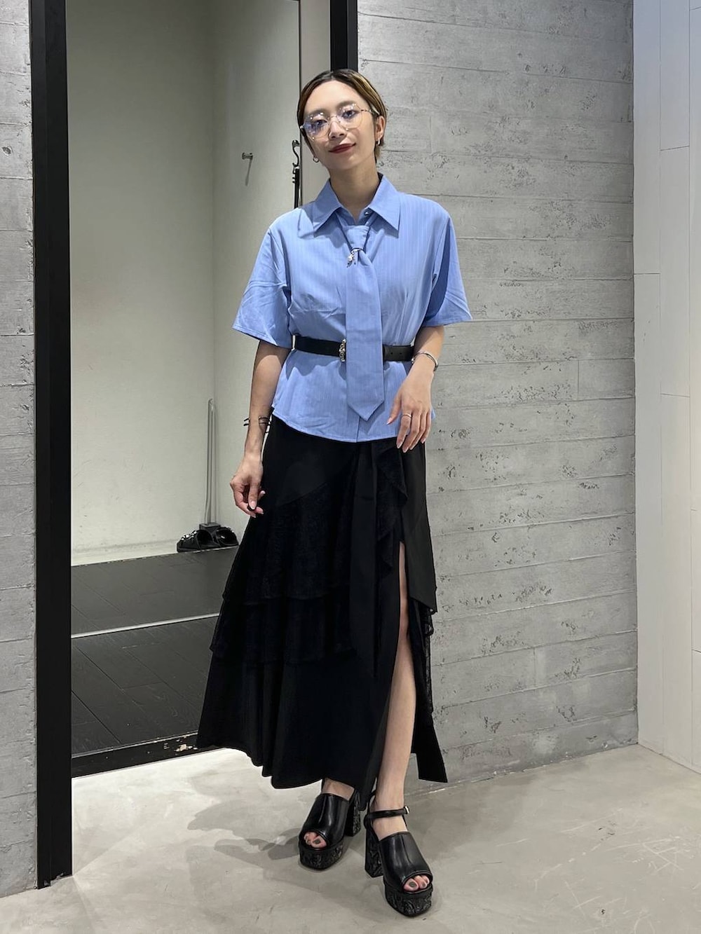 ブルー系のシャツ/ブラウス、ブラック系のサンダル、ブラック系のスカートを着用したレディースの夏コーディネートの4枚目の写真