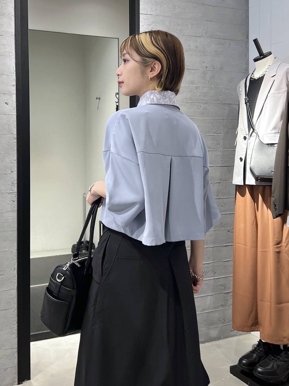 ブラック系のサンダル、ブラック系のボストンバッグ、ブルー系のシャツ/ブラウスを着用したレディースの春コーディネートの3枚目の写真