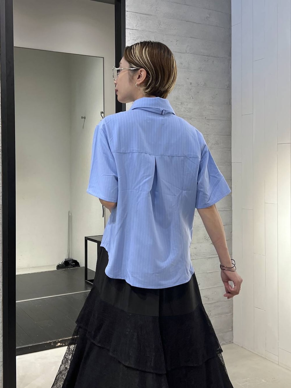 ブルー系のシャツ/ブラウス、ブラック系のサンダル、ブラック系のスカートを着用したレディースの夏コーディネートの3枚目の写真