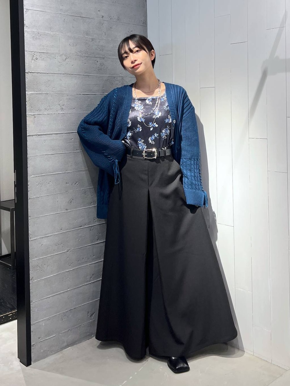 ブルー系のカーディガン/ボレロ、ブラック系のブーツ、ブラック系のその他パンツを着用したレディースの秋コーディネートの4枚目の写真