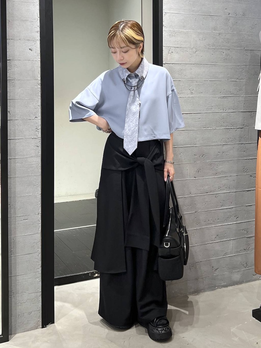 ブラック系のサンダル、ブラック系のボストンバッグ、ブルー系のシャツ/ブラウスを着用したレディースの春コーディネートの4枚目の写真