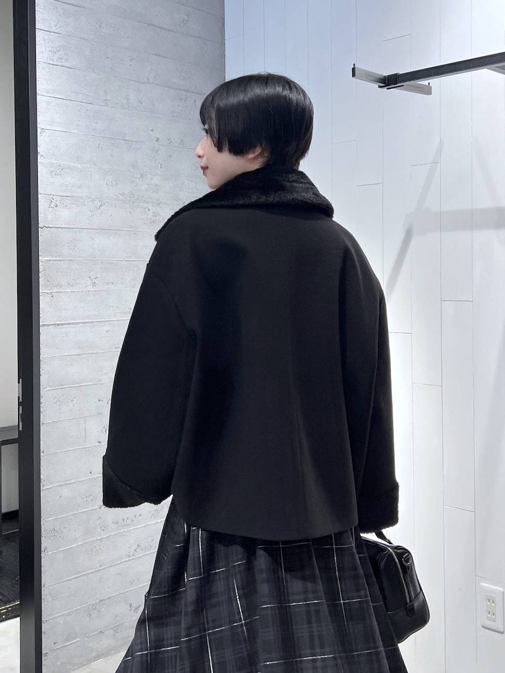 ブラック系のピーコート、ブラック系のニット/セーター、ブラック系のボストンバッグを着用したレディースの秋コーディネートの6枚目の写真