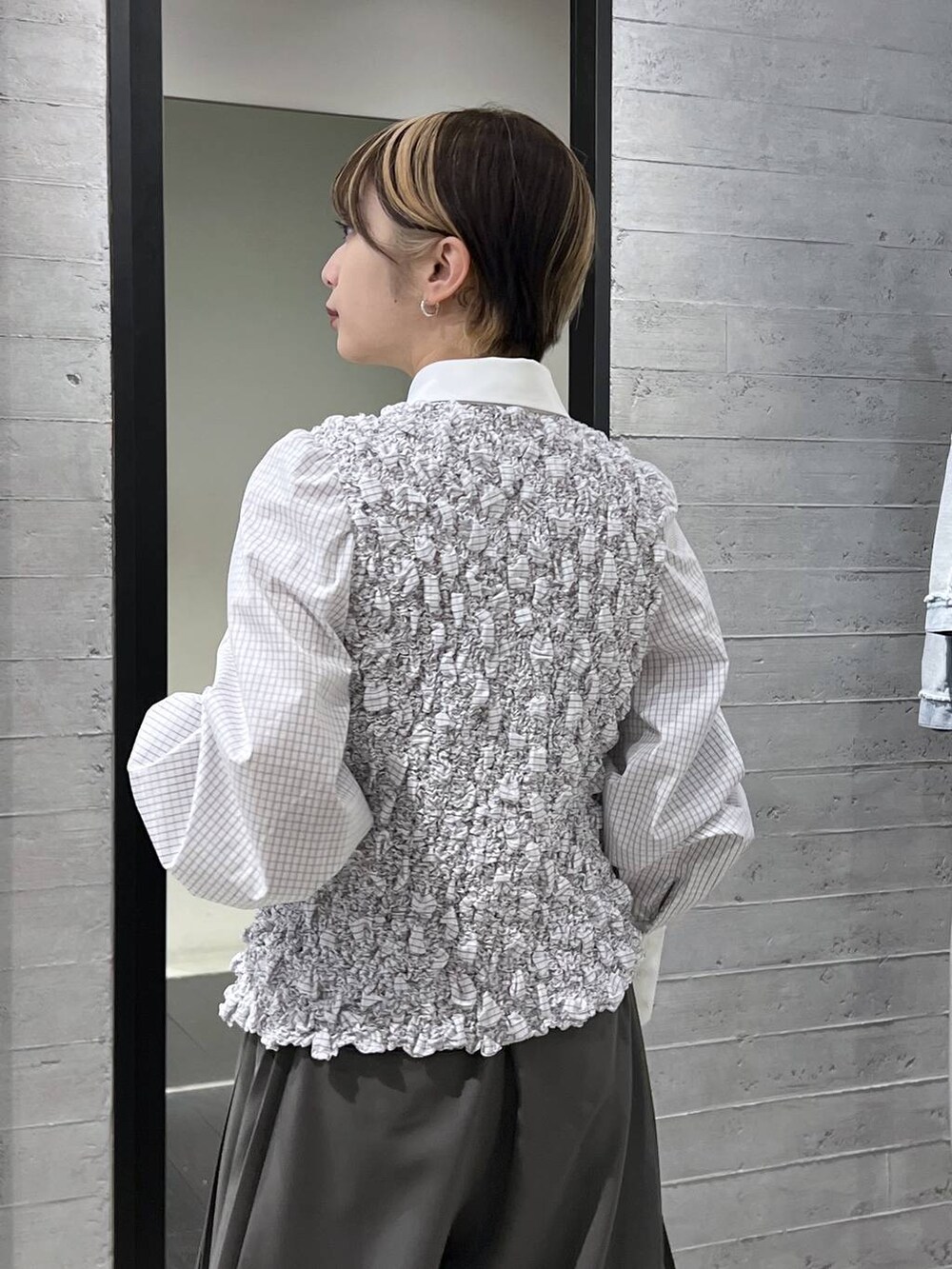 ブラック系のブーツ、ホワイト系のシャツ/ブラウス、グレー系のスラックスを着用したレディースの冬コーディネートの3枚目の写真