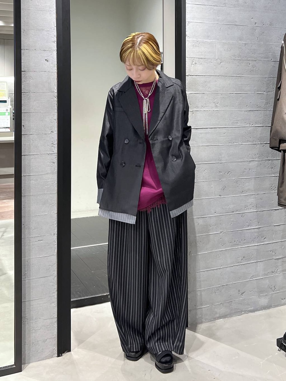 ブラック系のブーツ、ピンク系のTシャツ/カットソー、ブラック系のスラックスを着用したレディースの春コーディネートの4枚目の写真