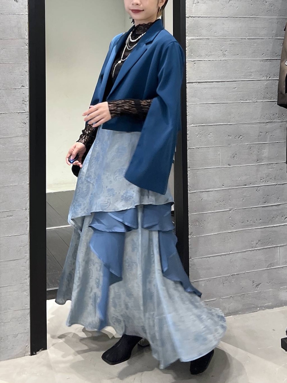 ブラック系のブーツ、グリーン系のテーラードジャケット、ブラック系のショルダーバッグを着用したレディースの春コーディネートの4枚目の写真