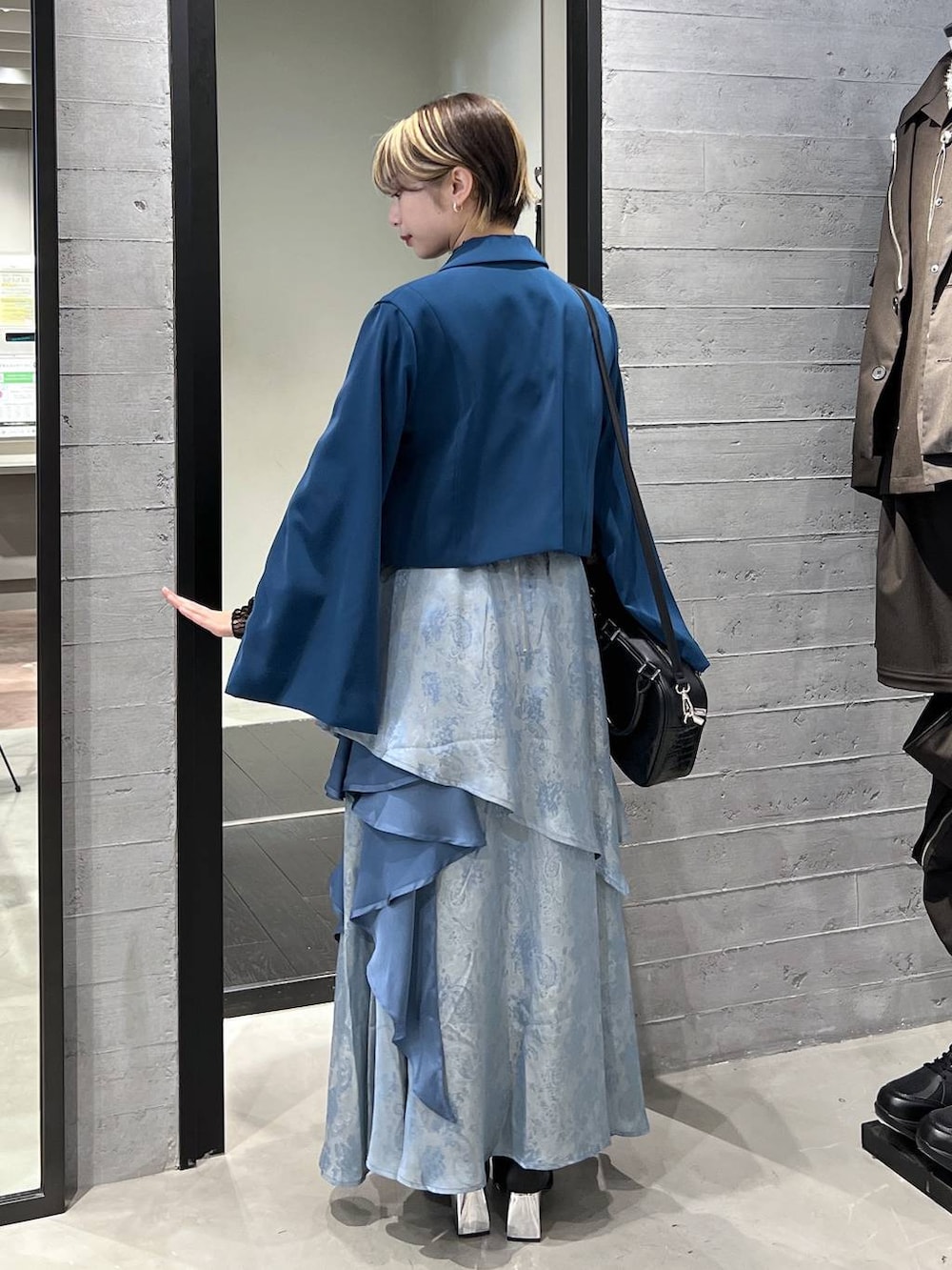 ブラック系のブーツ、グリーン系のテーラードジャケット、ブラック系のショルダーバッグを着用したレディースの春コーディネートの5枚目の写真