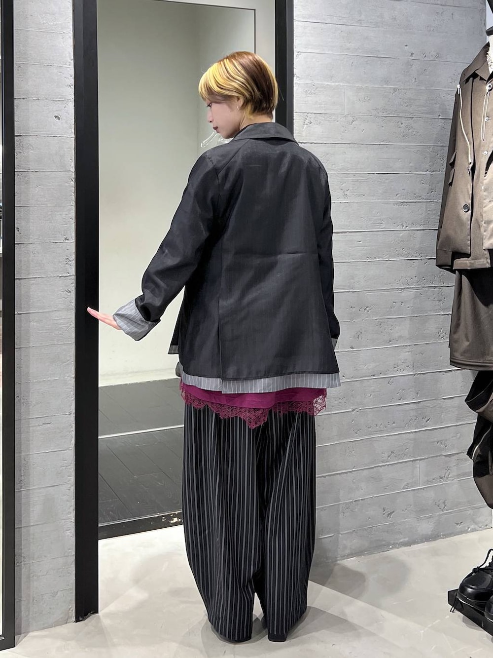 ブラック系のブーツ、ピンク系のTシャツ/カットソー、ブラック系のスラックスを着用したレディースの春コーディネートの6枚目の写真