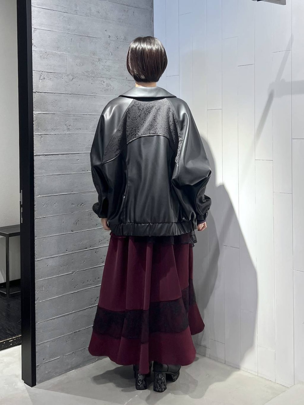 ブラック系のニット/セーター、ブラック系のブルゾン、ブラック系のブーツを着用したレディースの秋コーディネートの4枚目の写真