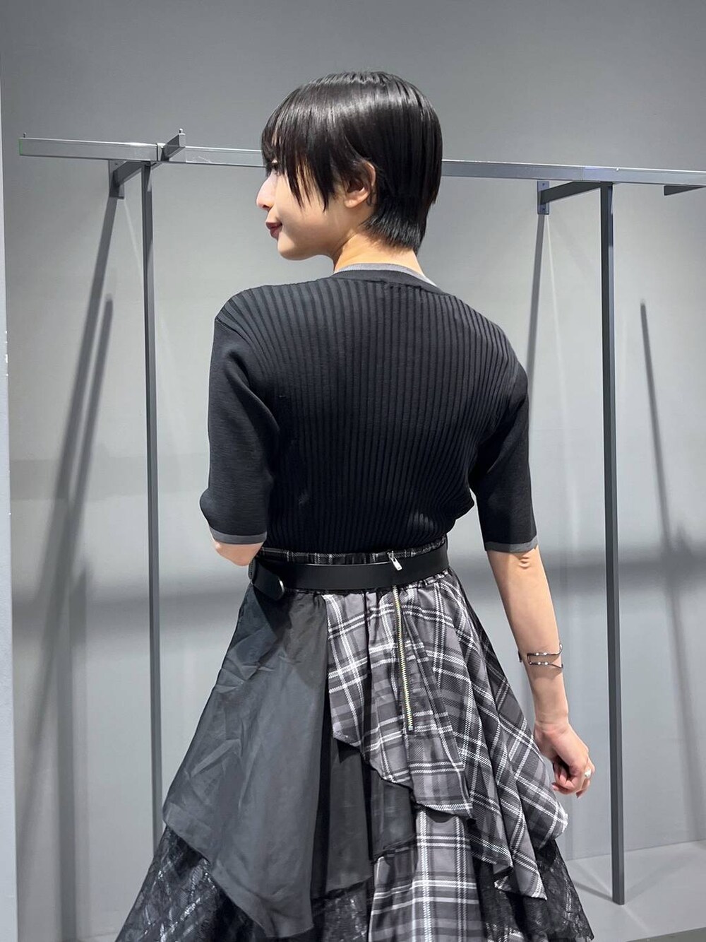 ブラック系のサンダル、ブラック系のニット/セーター、ブラック系のスカートを着用したレディースの夏コーディネートの3枚目の写真